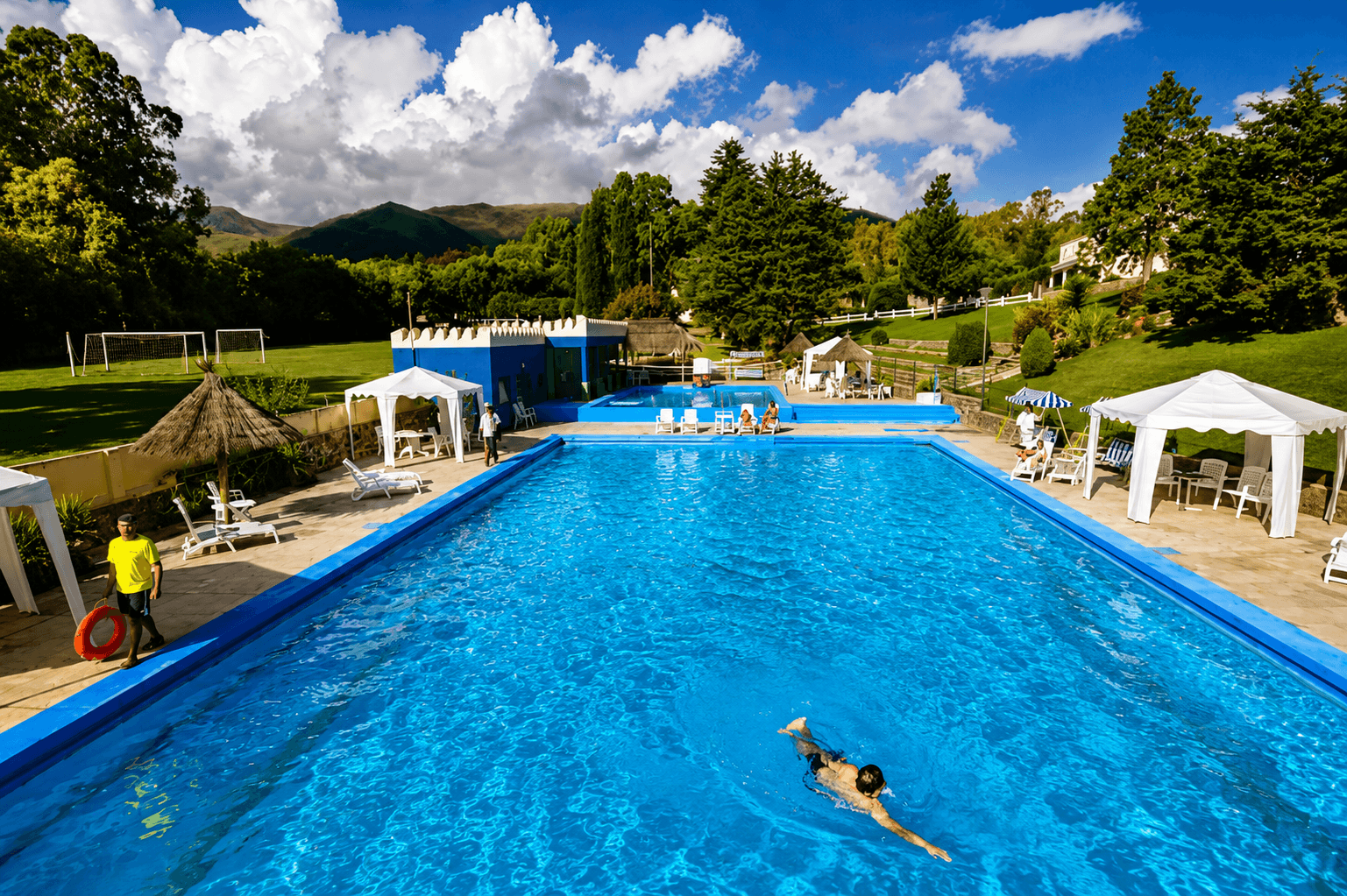 Pileta del hotel con viajeros disfrutando y vistas a las montañas